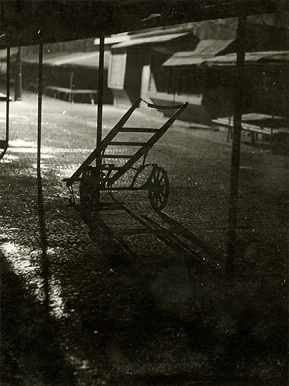 Two-Wheel Cart in Front of Market Stores at Night