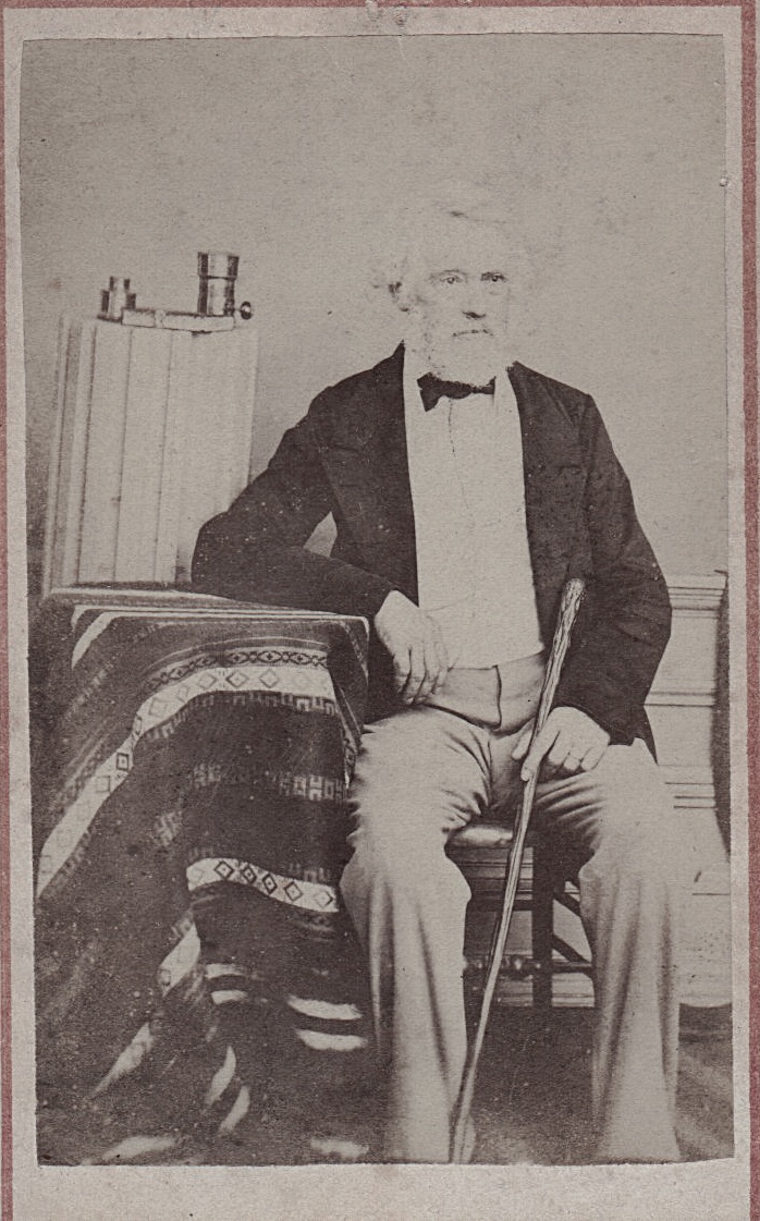 Paul Méténier. - Man Sitting by Pedestal with Lens and CDV Album